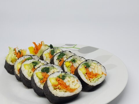 Side angle view of Korean kimbap rolls highlighting fresh vegetables and rice wrapped in seaweed.