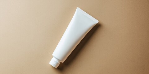 A white tube of toothpaste on a beige background.