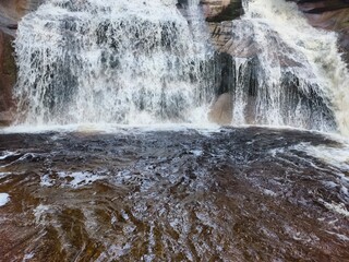 The Majestic Waterfall Cascading Gracefully Over the Rugged Rocky Terrain below it