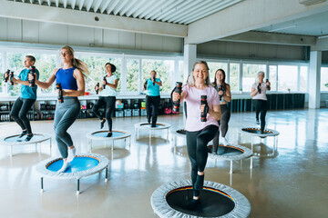 Group of active people exercising in gym doing yoga and fitness workouts promoting strength teamwork motivation and healthy lifestyle