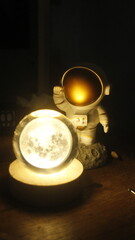 small statue or figure of an astronaut in white on a dark background