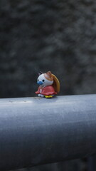 a toy cat wearing a hat is sitting in nature