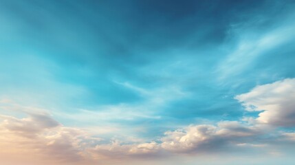 Obraz premium A serene sky with soft clouds transitions from light blue to warm hues, creating a tranquil atmosphere.