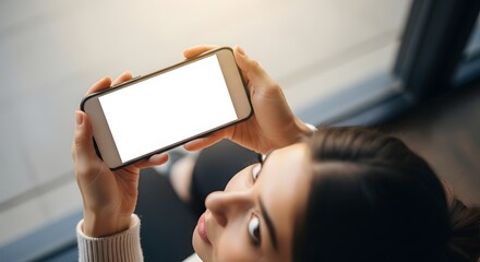Overhead view of woman holding a blank smartphone screen, focused on mobile content