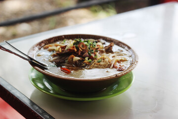 A bowl of delicious noodle soup served with vegetables and meat