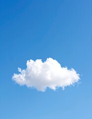 A fluffy white cloud drifts lazily across a bright blue sky, illuminated by the warm sunlight, creating a serene and tranquil atmosphere.