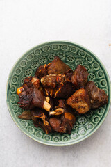 Fototapeta premium overhead view of fried goat meat on a green plate, top view of fried mutton