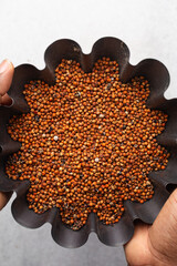 Overhead view of dusty and dirty red guinea corn also known as sorghum in a basket
