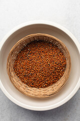 Overhead view of dusty and dirty red guinea corn also known as sorghum in a basket