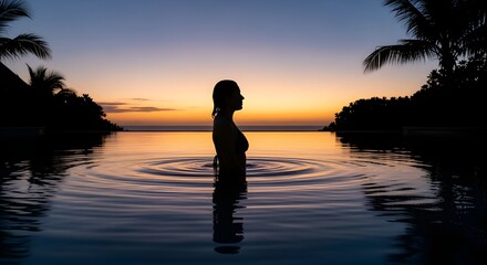 Fototapeta premium silhouette of a woman in the pool enjoying sunset