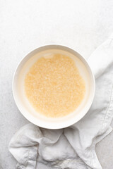 Overhead view of washed long grain rice in a white bowl