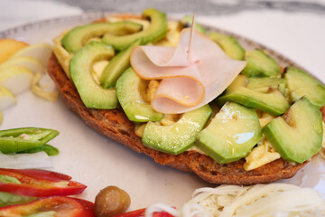 Delicious sandwich topped with fresh avocado and meat