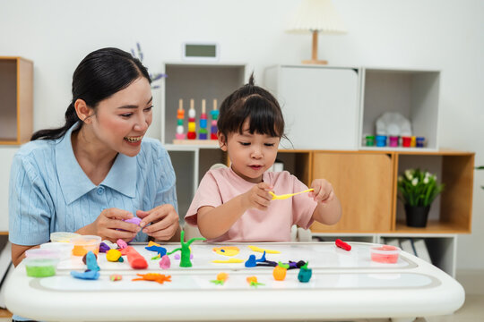 toddler girl with mother sculpting from plasticine at home