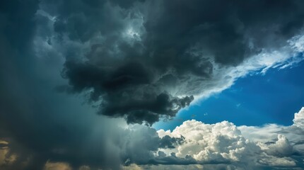 A dramatic sky with dark storm clouds gathering on one side and bright white cumulus clouds illuminated by sunlight on the other a striking contrast of weather conditions.
