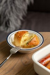 Savory Bread Roll with a Bite Taken Out, Served with Sausages, stock photo