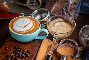 Barista Tools: Latte Art Setup with Portafilter, Milk Jug, and Espresso Cups on Wooden Table Latte Art Training: Workshop Setting with Milk Pouring Jug, Coffee Cups, and Barista Tools