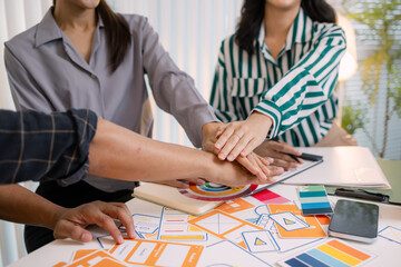Fototapeta premium Designers having a UX/UI planning meeting to refine mobile app layouts and user flow. They collaborate closely to create functional and visually appealing interface solutions.