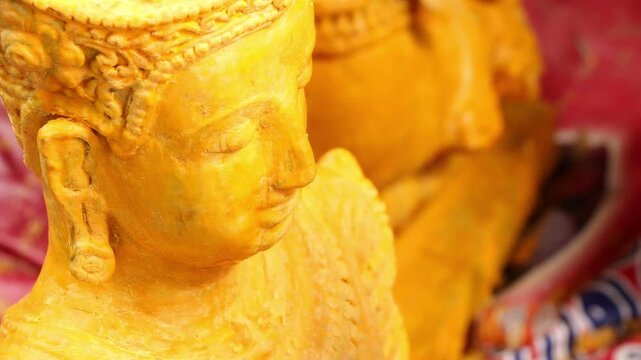 Hand carving a giant Buddhist Lent candle float sculpture in Chiang Rai Thailand.