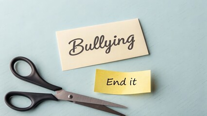 "Bullying" note cut by scissors with "End it" message, anti bullying concept