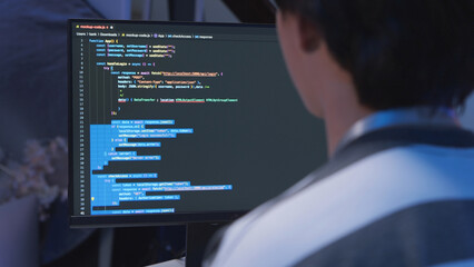 One young male Asian IT freelancer programmer and tech engineer working with computer keyboard, typing software codes for application development and website network system information data in room.