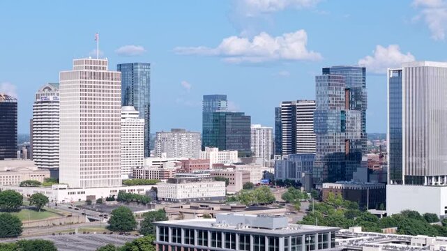 Downtown Nashville aerial rising of the music city with tall skyscraper buildings during the day time with some cloud coverage 