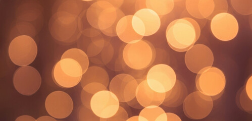 Abstract background filled with warm blurred golden lights that create a smooth bokeh effect, glowing softly to evoke elegance, warmth, and artistic atmosphere.