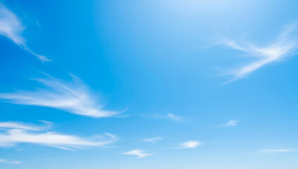 Blue sky with wispy white clouds on a sunny day, filled with gentle light and a feeling of freedom, representing clear weather and a sense of openness in nature’s beauty.