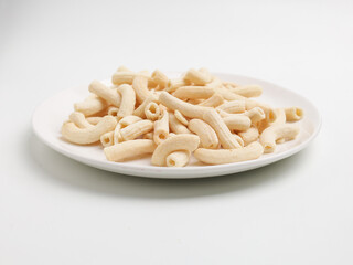 Crunchy macaroni snacks, piled on white background