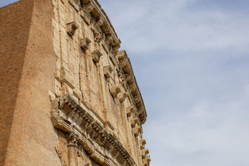 A detailed close-up captures a section of the ornate, historic wall of the Colosseum in Rome, Italy.