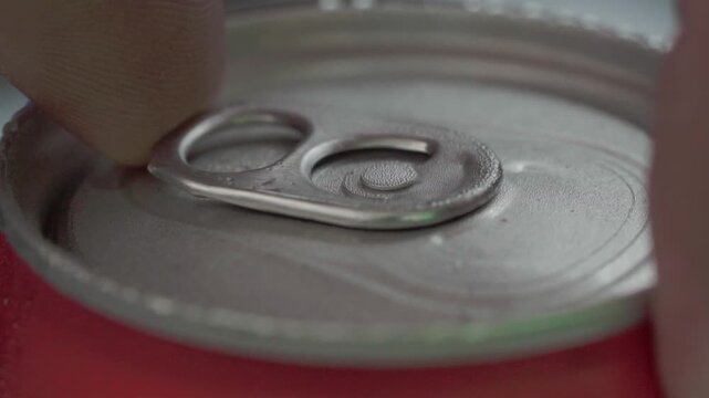 Hand opening soda can, close-up view, concept of refreshment and thirst