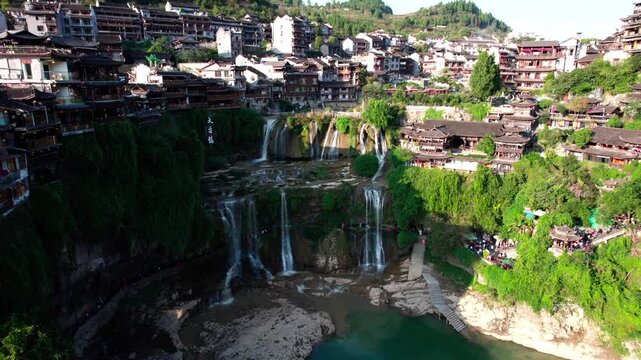 The ancient houses of Furong Town hanging on the cliff waterfall