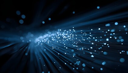 Abstract glowing blue light particles emanating from a central point creating a futuristic and technological sense of motion and energy flow in darkness