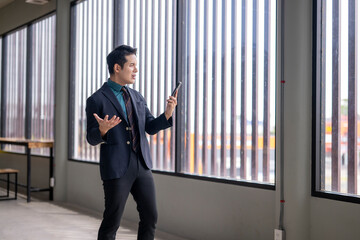 Businessman recording voice message using smartphone app in office