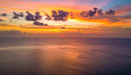Vibrant sunset over the ocean with dramatic clouds.