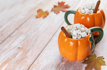 Pumpkin shaped mugs with hot chocolate and marshmallows