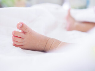 Close up of newborn baby feet on white blanket