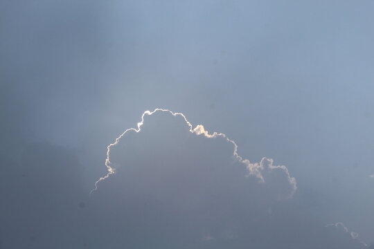 Bright Cumulus Cloud with Silver Lining Against Clear Blue Sky