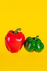 Red,yellow and green sweet peppers on yellow background