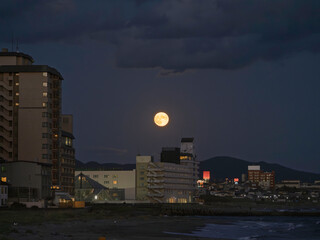 満月の夜の街と川の明かり