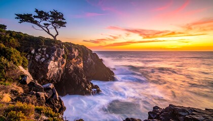 Coastal scene featuring a lone tree atop rugged cliffs, waves crashing below, under a vibrant, colorful sunset sky