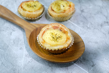 Homemade mini tarts placed on a rustic wooden board with a warm natural background. Perfect for food blogs, bakery advertisements, or recipe illustrations