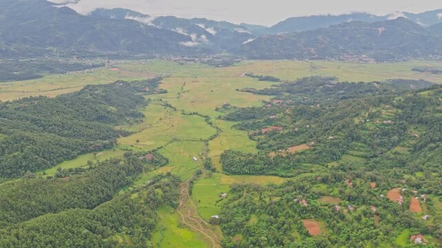 Aerial view of lush green paddy fields in Tansen Palpa, Nepal, surrounded by beautiful mountains and rural landscapes, showcasing the region&rsquo;s rich agriculture and natural beauty.