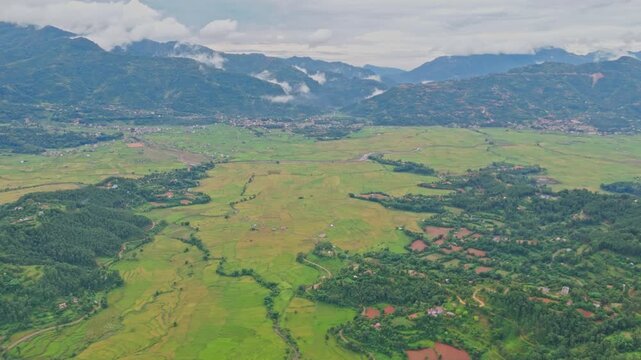 Aerial view of lush green paddy fields in Tansen Palpa, Nepal, surrounded by beautiful mountains and rural landscapes, showcasing the region&rsquo;s rich agriculture and natural beauty.