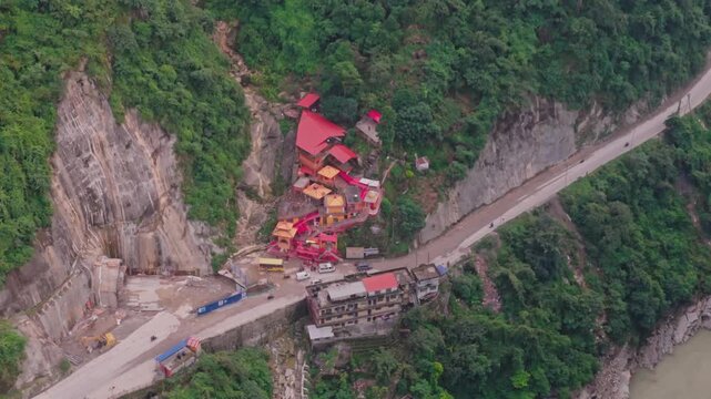 Aerial drone footage of the famous Siddhababa Temple in Tansen Palpa, Nepal, located on a scenic hillside with winding mountain roads and stunning natural surroundings.