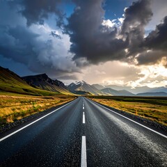Naklejka premium Asphalt road stretches toward mountains under a dramatic, cloudy sky