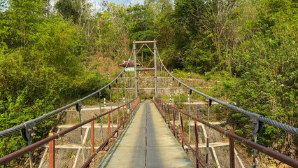 Suspension bridge front view surrounded by forest
