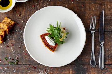 Mini tomato tart topped with burrata and peppery arugula garnish