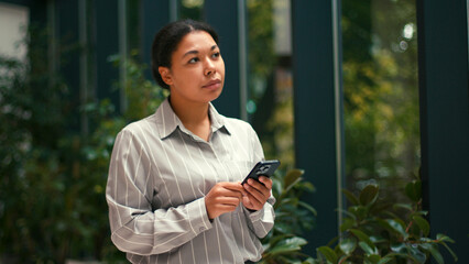 Happy, Hispanic Business Woman Work Using Smartphone Phone. Motivation, Success at Office. Excited, Employee, Lawyer, Female Businesswoman Corporate Job. Greenhouse background