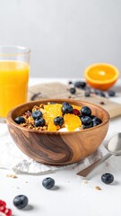 Granola, fruit, yogurt in wooden bowl. Juice on the side