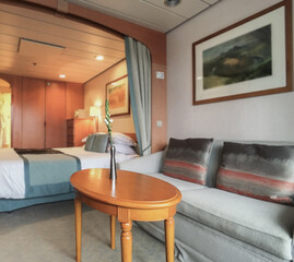 Doppelbett mit Dekokissen vor Schiebetür in Balkonkabine auf Kreuzfahrtschiff - Modern interior...